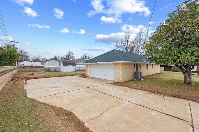 view of property exterior with a lawn, central air condition unit, and a garage