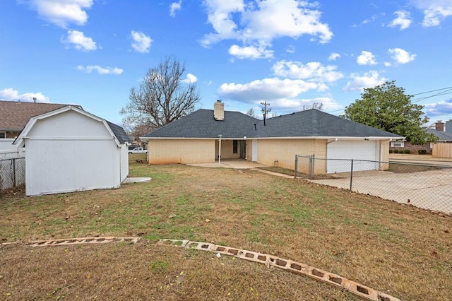 back of property with a garage and a yard