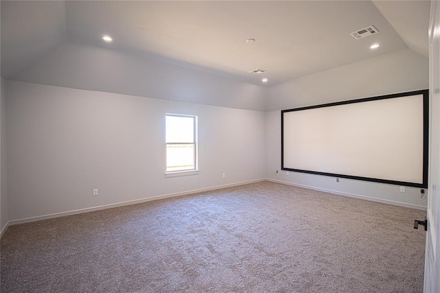 carpeted cinema room with lofted ceiling