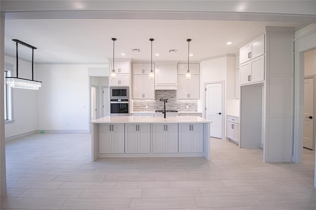 kitchen featuring pendant lighting, a kitchen island with sink, oven, and built in microwave