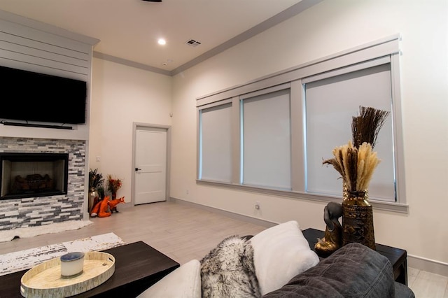 living room with light wood-type flooring and a stone fireplace