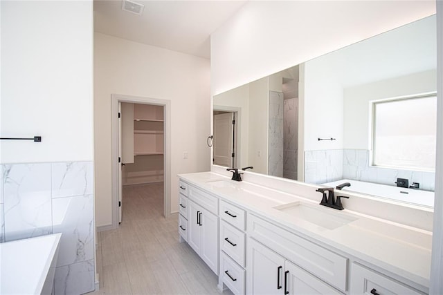 bathroom with a tub to relax in and vanity