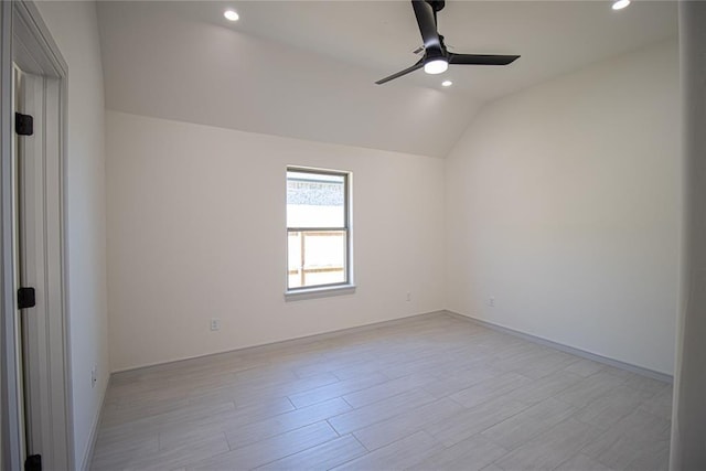 empty room with ceiling fan, lofted ceiling, and light hardwood / wood-style flooring