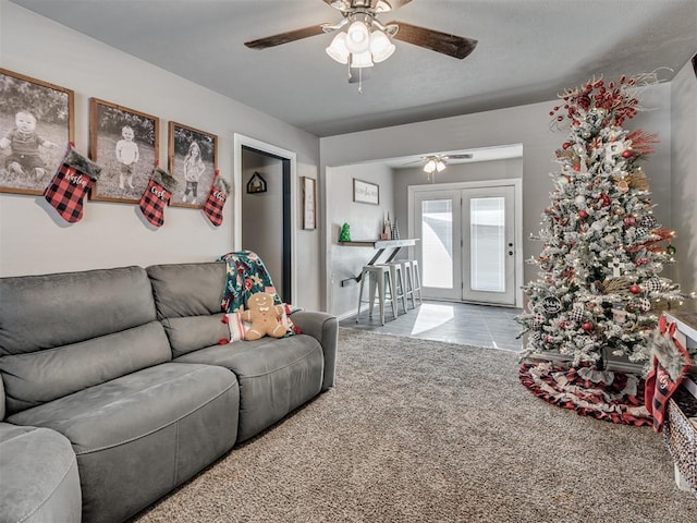 carpeted living room featuring ceiling fan and french doors