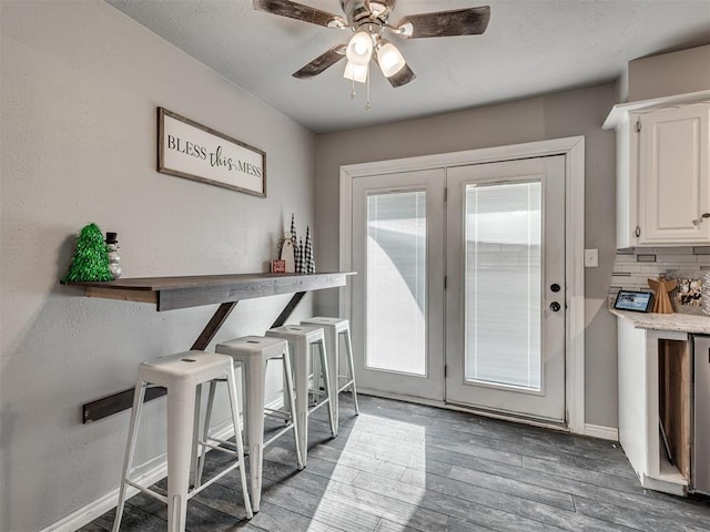 doorway to outside featuring wood-type flooring and ceiling fan