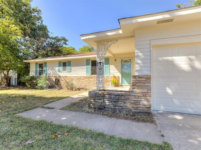 1847 N Allen Ln, Oklahoma City, OK 73127 - entrance to property featuring an attached garage, a lawn, and stone siding