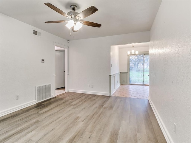 unfurnished room featuring light hardwood / wood-style floors and ceiling fan with notable chandelier