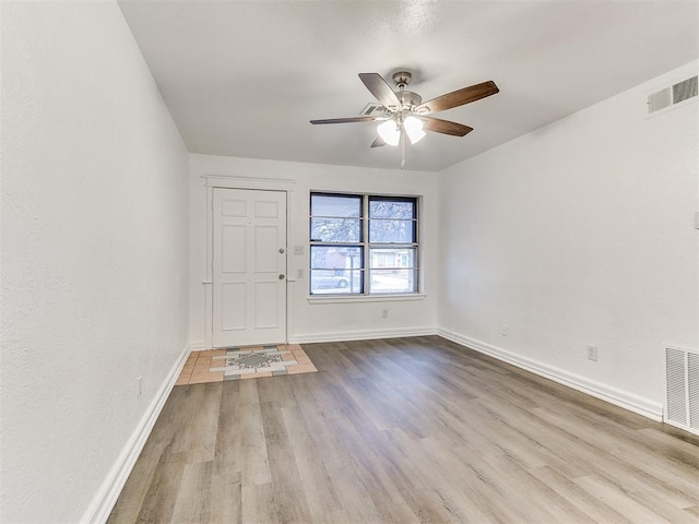 empty room featuring ceiling fan and light hardwood / wood-style floors