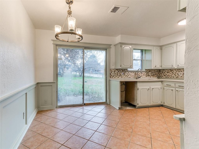 kitchen with a notable chandelier, decorative light fixtures, light tile patterned floors, and sink