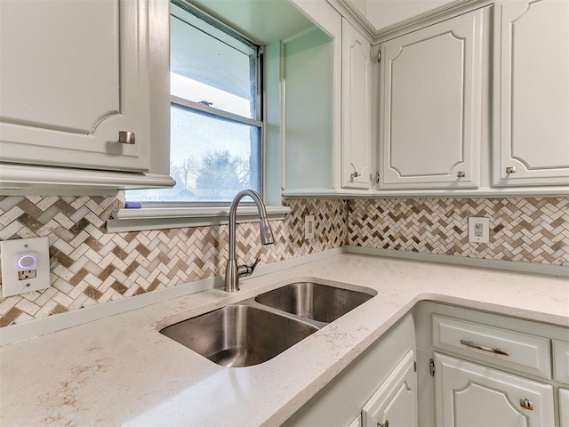 kitchen featuring backsplash, white cabinetry, and sink