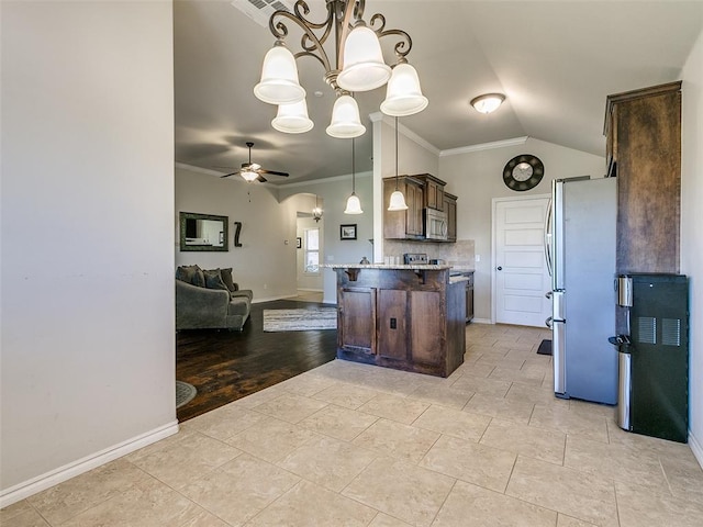 kitchen featuring dark brown cabinets, ceiling fan with notable chandelier, stainless steel appliances, crown molding, and decorative light fixtures