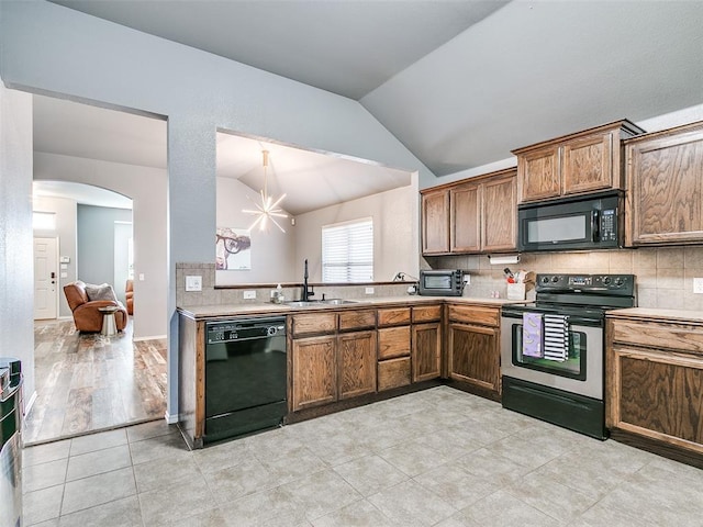 kitchen with backsplash, sink, black appliances, a chandelier, and lofted ceiling