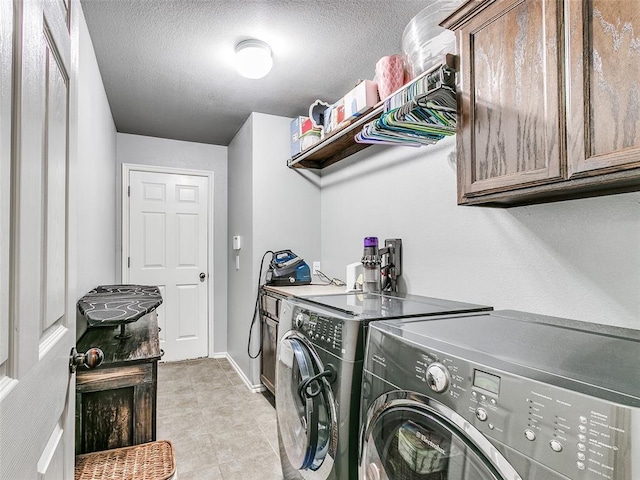 laundry area with cabinets, independent washer and dryer, a textured ceiling, and light tile patterned floors