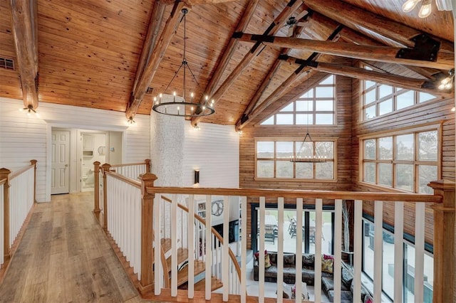 corridor with wooden ceiling, high vaulted ceiling, light wood-type flooring, beam ceiling, and a chandelier