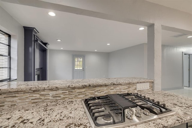 kitchen with light stone counters and stainless steel gas cooktop