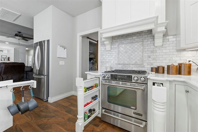 kitchen featuring appliances with stainless steel finishes, backsplash, ceiling fan, dark hardwood / wood-style floors, and white cabinetry