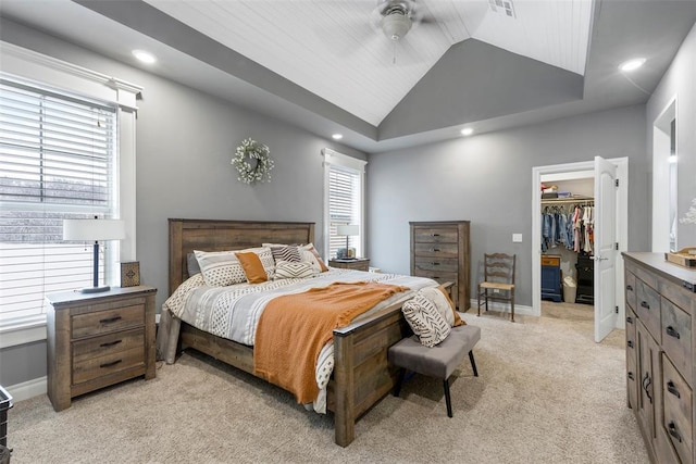 bedroom featuring a spacious closet, ceiling fan, vaulted ceiling, multiple windows, and a closet