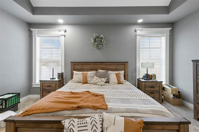 carpeted bedroom featuring a raised ceiling