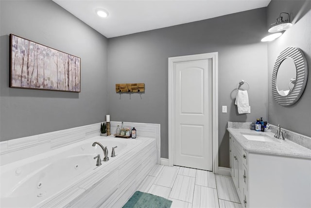 bathroom featuring vanity and tiled tub