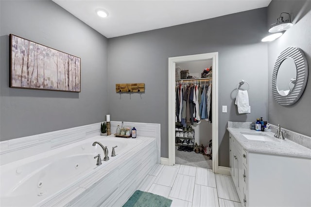 bathroom with vanity and a relaxing tiled tub