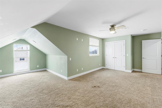 additional living space with carpet, lofted ceiling, ceiling fan, and a healthy amount of sunlight