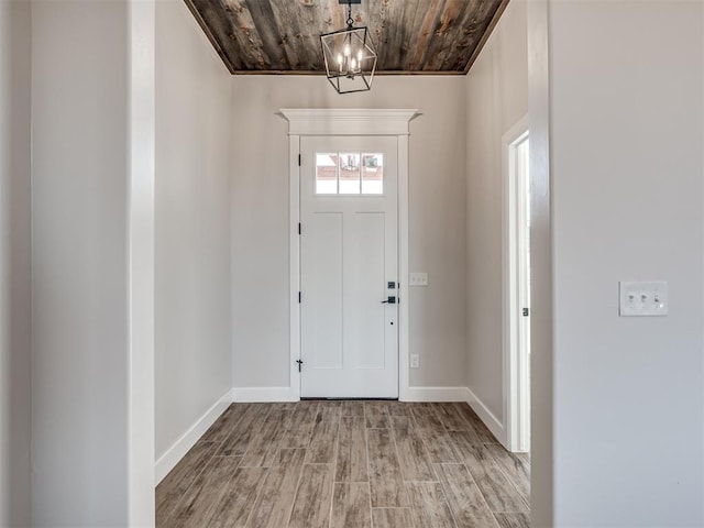 entryway featuring a chandelier, light hardwood / wood-style floors, and wood ceiling