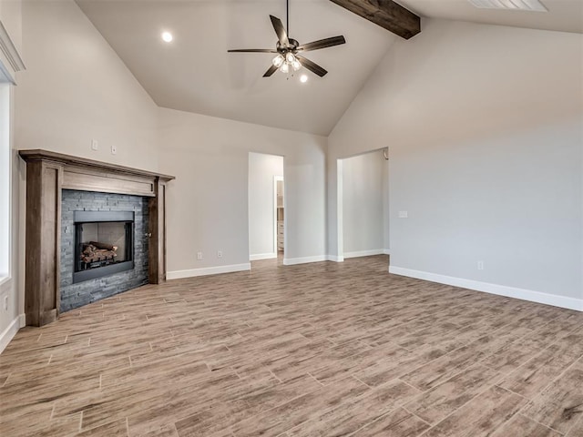 unfurnished living room featuring beam ceiling, a stone fireplace, ceiling fan, and high vaulted ceiling