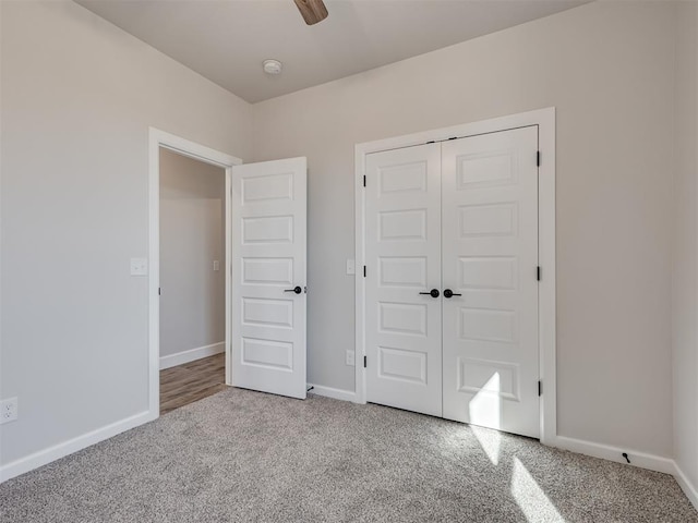 unfurnished bedroom featuring ceiling fan, light colored carpet, and a closet