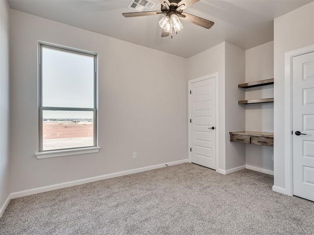 carpeted spare room with ceiling fan