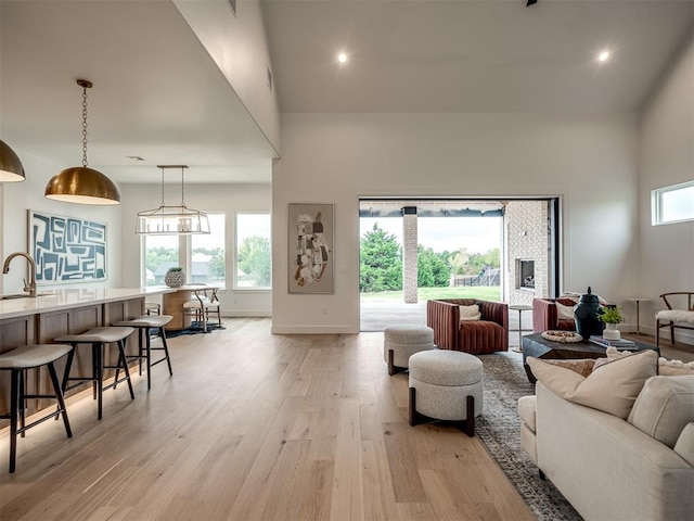 living room featuring a chandelier, light hardwood / wood-style flooring, and sink