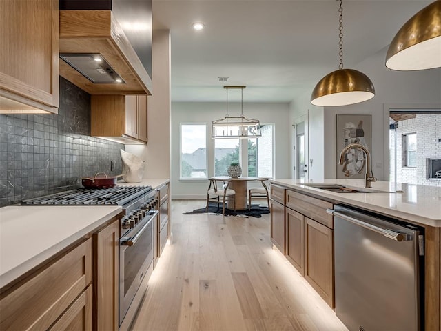 kitchen featuring pendant lighting, custom exhaust hood, sink, decorative backsplash, and stainless steel appliances