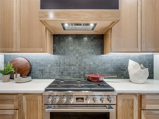 kitchen featuring tasteful backsplash, light brown cabinetry, and high end range