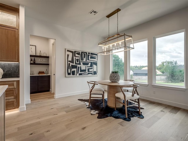 dining space with a chandelier and light hardwood / wood-style floors