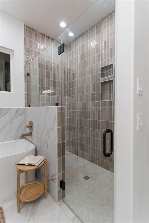 bathroom with separate shower and tub and tile walls