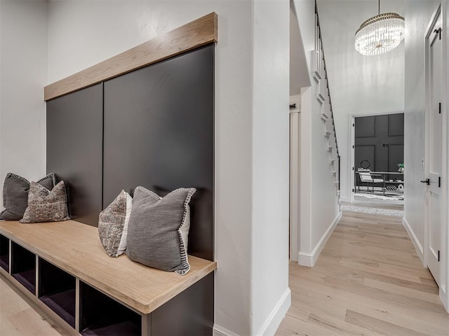 mudroom with light hardwood / wood-style floors and an inviting chandelier