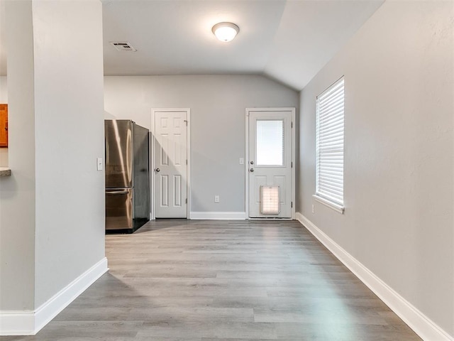 foyer with light hardwood / wood-style flooring and lofted ceiling