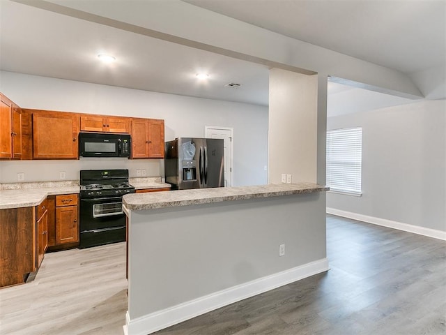 kitchen with black appliances and light hardwood / wood-style floors