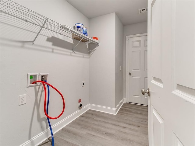 laundry area with hookup for a washing machine, light hardwood / wood-style floors, and electric dryer hookup