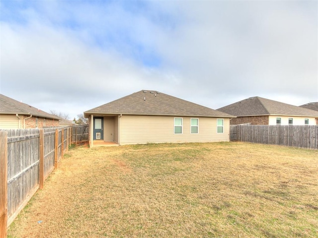 rear view of property featuring a lawn