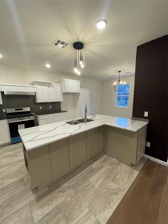 kitchen featuring white cabinetry, a large island, stainless steel stove, and pendant lighting