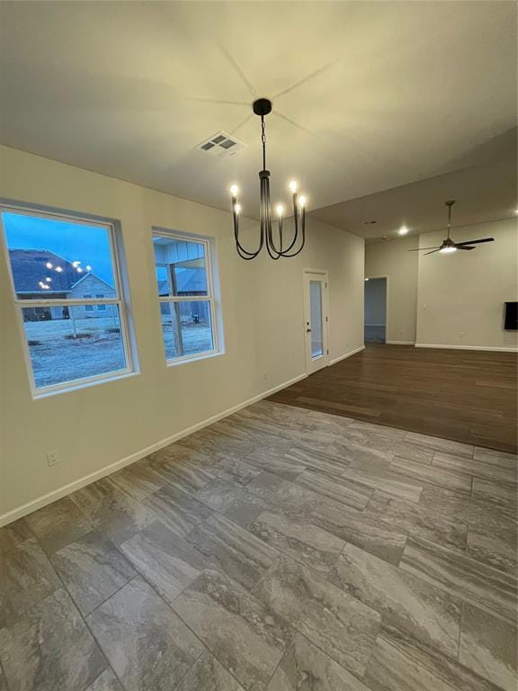 unfurnished dining area with ceiling fan with notable chandelier