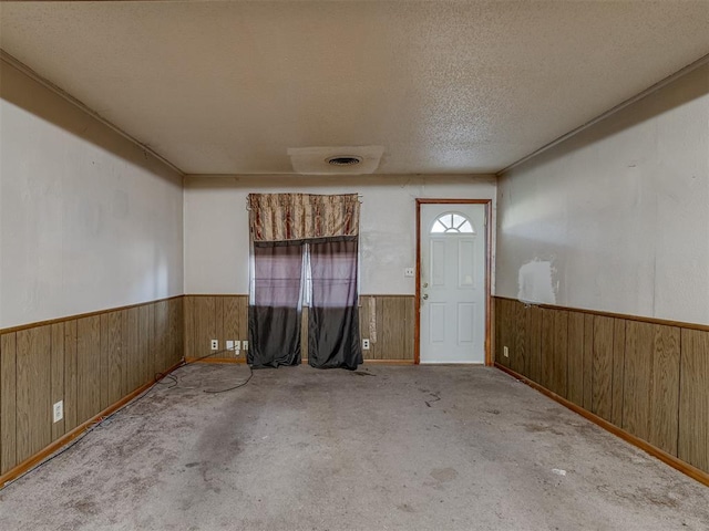 carpeted foyer featuring a textured ceiling