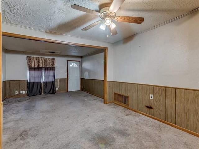 empty room with light carpet, a textured ceiling, and ceiling fan