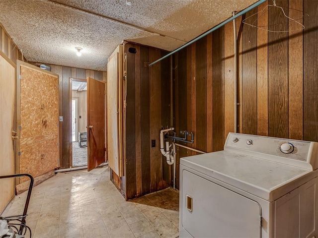 clothes washing area featuring washer / dryer and wood walls