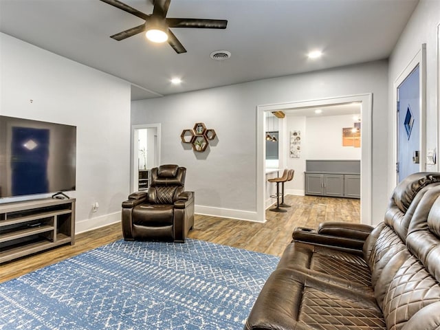 living room with ceiling fan and light hardwood / wood-style flooring