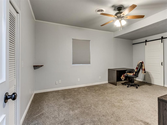 office area featuring a barn door, ceiling fan, carpet, and ornamental molding