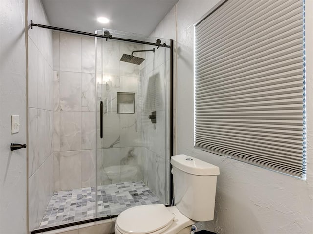 bathroom featuring toilet and walk in shower