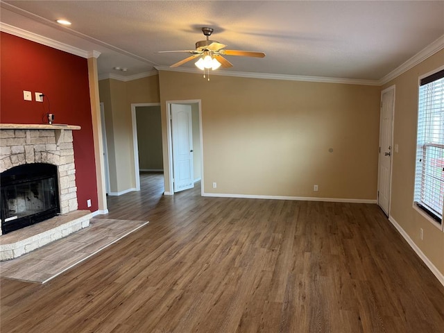 unfurnished living room with hardwood / wood-style floors, a stone fireplace, ceiling fan, and ornamental molding