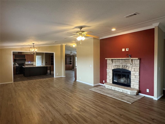 unfurnished living room with a stone fireplace, crown molding, and dark wood-type flooring