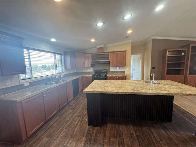 kitchen featuring sink, an island with sink, black appliances, and vaulted ceiling